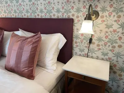 a bed with a lamp and a side table at Jugend 1902 in Ålesund