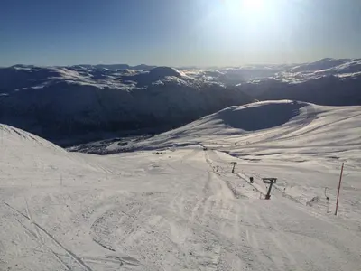 a snow covered ski slope with the sun in the background at Voss-Oppheim Resort appartment witc acess to swimmingpool in Øyjordi