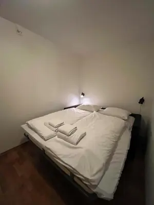 a bed in a room with white sheets and pillows at Voss-Oppheim Resort appartment witc acess to swimmingpool in Øyjordi