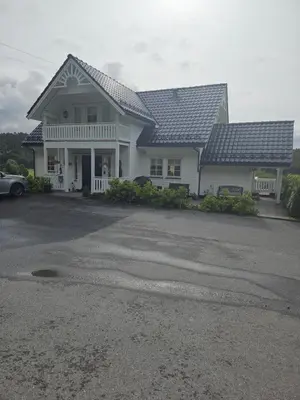 a large white house with a driveway at Gårdsidyll i flotte omgivelser in Ålesund