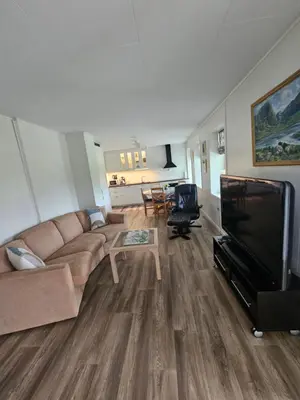 a living room with a couch and a flat screen tv at Gårdsidyll i flotte omgivelser in Ålesund
