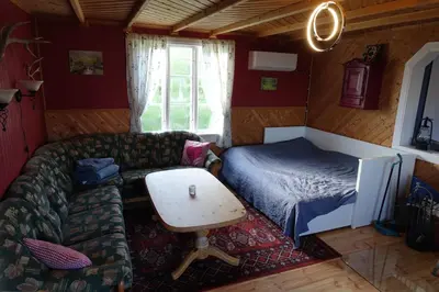 a room with a couch and a bed and a table at Guesthouse Hamran in Mosvik