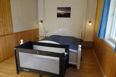 a small bedroom with a bed with a blue blanket at Guesthouse Hamran in Mosvik