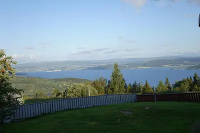 a yard with a fence and a view of a lake at Guesthouse Hamran in Mosvik