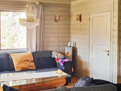 a living room with a blue couch and a window at 6 person holiday home in Flatanger in Lauvsnes