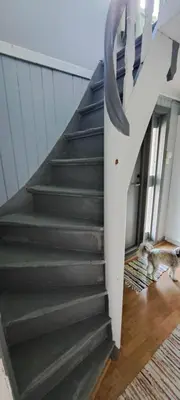 a staircase in a house with a dog laying on the floor at Åsenfjord, feriehus ved sjøen in Hopla