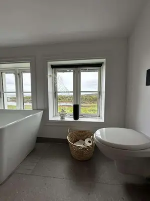 a bathroom with a tub and a toilet and a sink at Sjønært småbruk in Bud