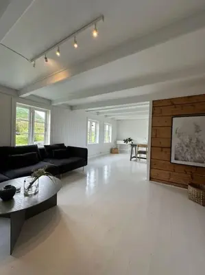 a living room with a black couch and a table at Sjønært småbruk in Bud