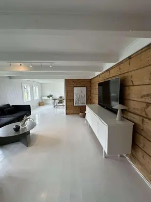 a large living room with a couch and a tv at Sjønært småbruk in Bud