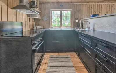 a large kitchen with black counter tops and a window at Koselig Fjellhytte Med Utsikt in Bykle