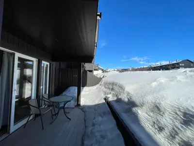 a porch with a table and chairs in the snow at Cozy 2-Bedroom Retreat In The Heart Of Nature in Beitostøl