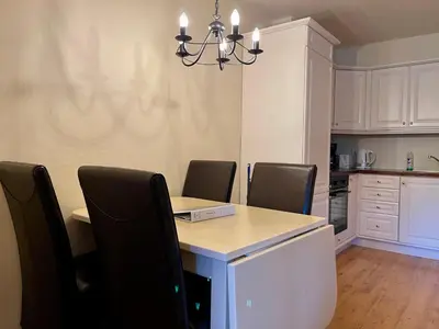 a dining room with a table and chairs and a kitchen at Cozy 2-Bedroom Retreat In The Heart Of Nature in Beitostøl