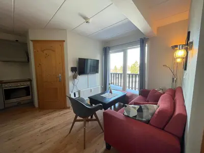 a living room with a red couch and a table at Small Family Retreat Two Bedrooms And Easy Access in Beitostøl