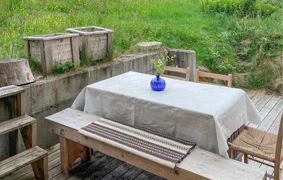 a table with a blue vase on top of it at Beautiful Home In Vassenden in Vassenden