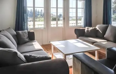 a living room with two couches and a table at 3 Bedroom Nice Home In Kvenvær in Kvenvær