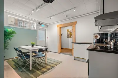 a kitchen with a table and chairs in a room at BUDGETEL- Kong Oscarsgate 48 in Bergen