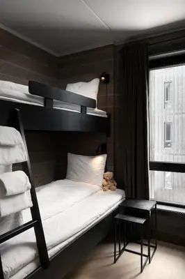 a room with two bunk beds and a table at Riddergaarden Hotel & Mountain Lodge, Beitostølen in Beitostøl