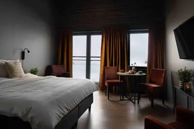 a bedroom with a bed and a table with chairs at Riddergaarden Hotel & Mountain Lodge, Beitostølen in Beitostøl