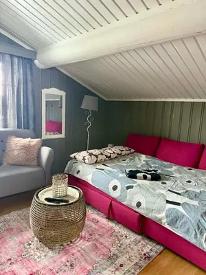 a bedroom with a large bed and a couch at Koia Guesthouse in Flesberg