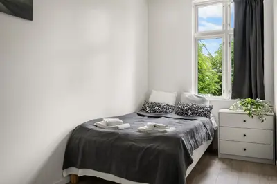 a small bedroom with a bed with a window at One of a kind in Bergen I 7 Bedrooms I 15 Guests! in Bergen