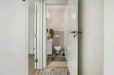 a white bathroom with a toilet and a door at One of a kind in Bergen I 7 Bedrooms I 15 Guests! in Bergen