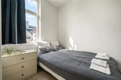 a bedroom with a bed with a dresser and a window at One of a kind in Bergen I 7 Bedrooms I 15 Guests! in Bergen