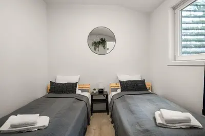 two beds in a room with a mirror on the wall at One of a kind in Bergen I 7 Bedrooms I 15 Guests! in Bergen