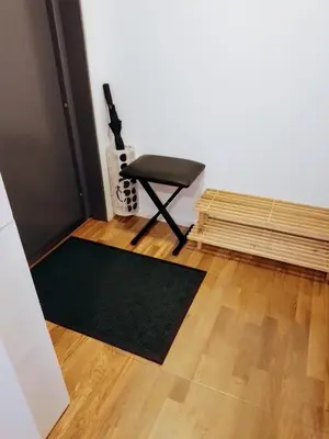 a room with a black chair and a green rug at Cosy apartment near city center in Bergen