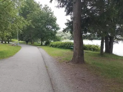 a walking path in a park next to a lake at Cosy apartment near city center in Bergen