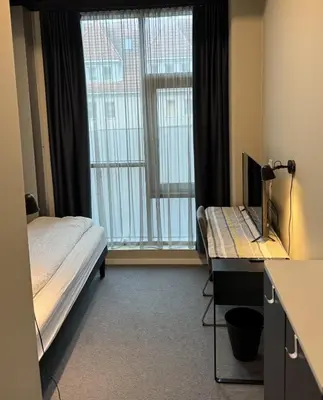 a bedroom with a bed and a desk with a computer at Lilleby Apartment in Trondheim