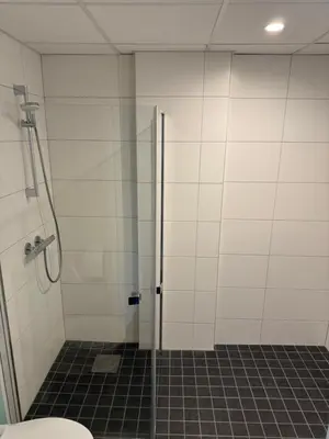 a bathroom with a shower stall and a toilet at Lilleby Apartment in Trondheim