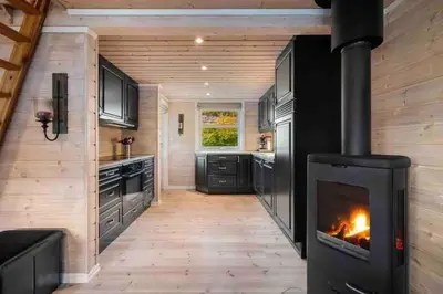 a kitchen with a fireplace in a tiny house at Rekkehus i Myrkdalen in Helgatun