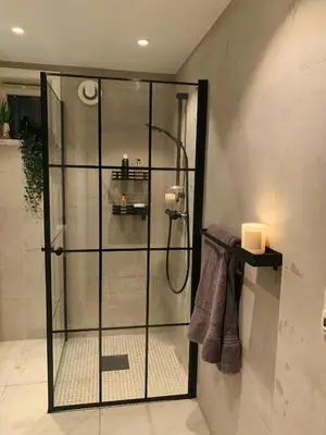 a shower with a glass door in a bathroom at Cozy Central Apartment in Ålesund in Ålesund