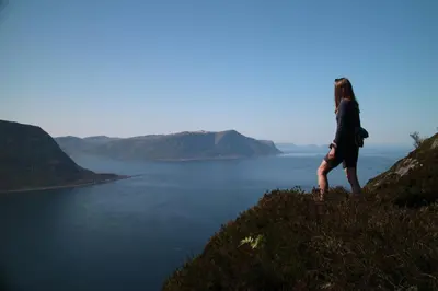 a woman standing on a hill overlooking a body of water at Cozy Central Apartment in Ålesund in Ålesund