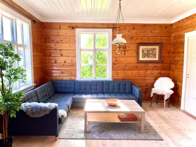 a living room with a blue couch and a table at Stryn - Faleide - hus ved fjorden in Stryn