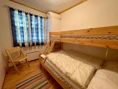 a bedroom with two bunk beds and a chair at Spacious Apartment In Central Beitostølen in Beitostøl