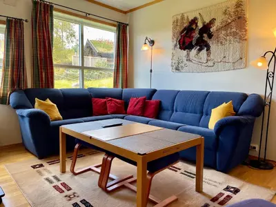 a blue couch in a living room with a table at Spacious Apartment In Central Beitostølen in Beitostøl