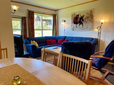 a living room with a blue couch and a table at Spacious Apartment In Central Beitostølen in Beitostøl