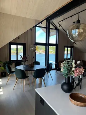 a kitchen and living room with a table and chairs at Amundøya Penthouse in Kristiansund