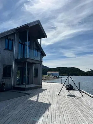 a house on a dock next to a body of water at Amundøya Penthouse in Kristiansund