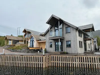 a house on a dock next to the water at Amundøya Penthouse in Kristiansund