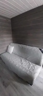 a bed with a white comforter in a room at Hos Jurate in Fagernes