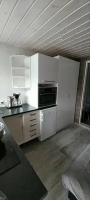 a kitchen with white cabinets and a black counter top at Hos Jurate in Fagernes