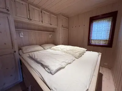 a large white bed in a room with a window at Panorama 4 C Ski Inn And Out With Views Of Slettefjell in Beitostøl