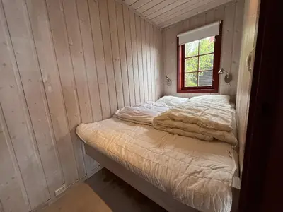 a small room with a bed with a window at Panorama 4 C Ski Inn And Out With Views Of Slettefjell in Beitostøl