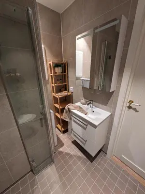 a bathroom with a sink and a shower at Meget hjemmekoseligISentraltINyoppusset leilighet in Bergen