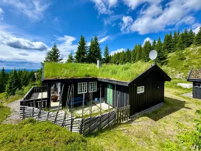 a house with a grass roof at Cozy spacious cabin with sauna at Natrudstilen in Ringsaker