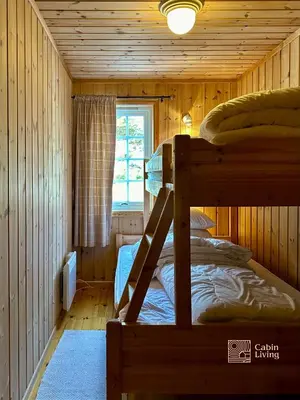 a bedroom with two bunk beds in a cabin at Cozy spacious cabin with sauna at Natrudstilen in Ringsaker