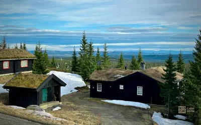 a couple of small buildings with grass roofs at Cozy spacious cabin with sauna at Natrudstilen in Ringsaker