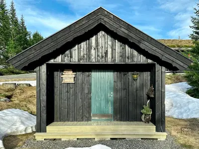 a small wooden outhouse with a window at Cozy spacious cabin with sauna at Natrudstilen in Ringsaker